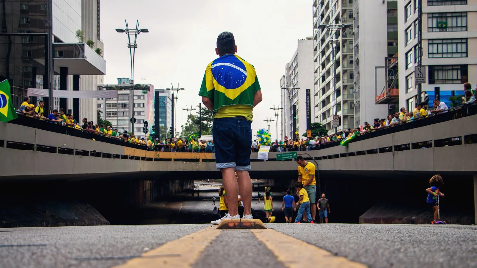 Street gathering in Brazil with people celebrating and wearing national flags.