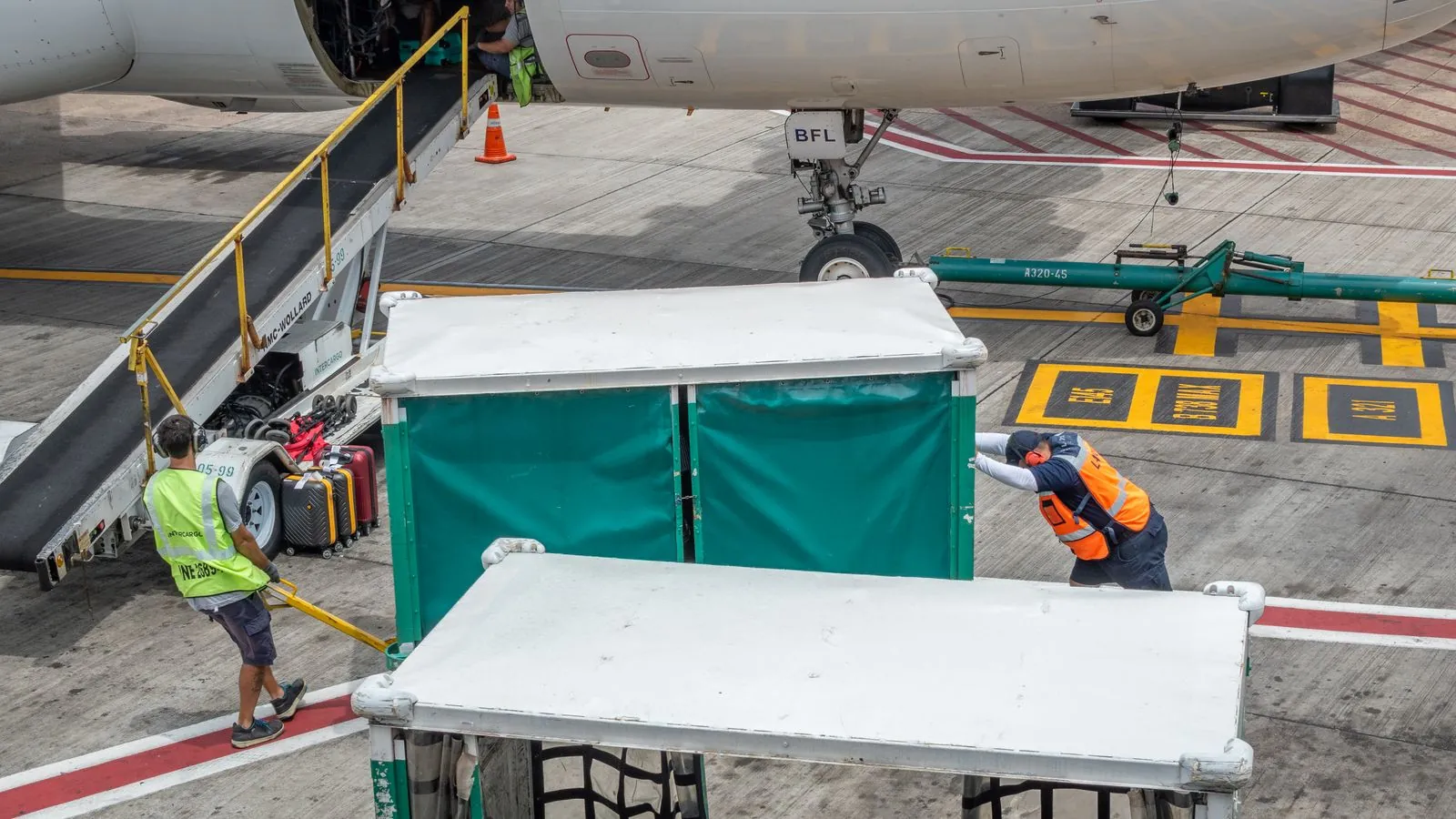 Ground crew at Chilean airport handling baggage for departing flight. Airport logistics in action.
