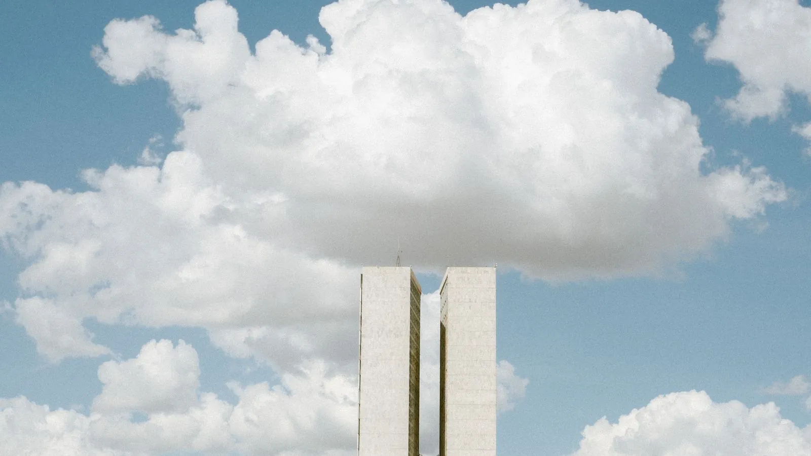 View of the National Congress in Brasília with impressive cloud formations in the sky.