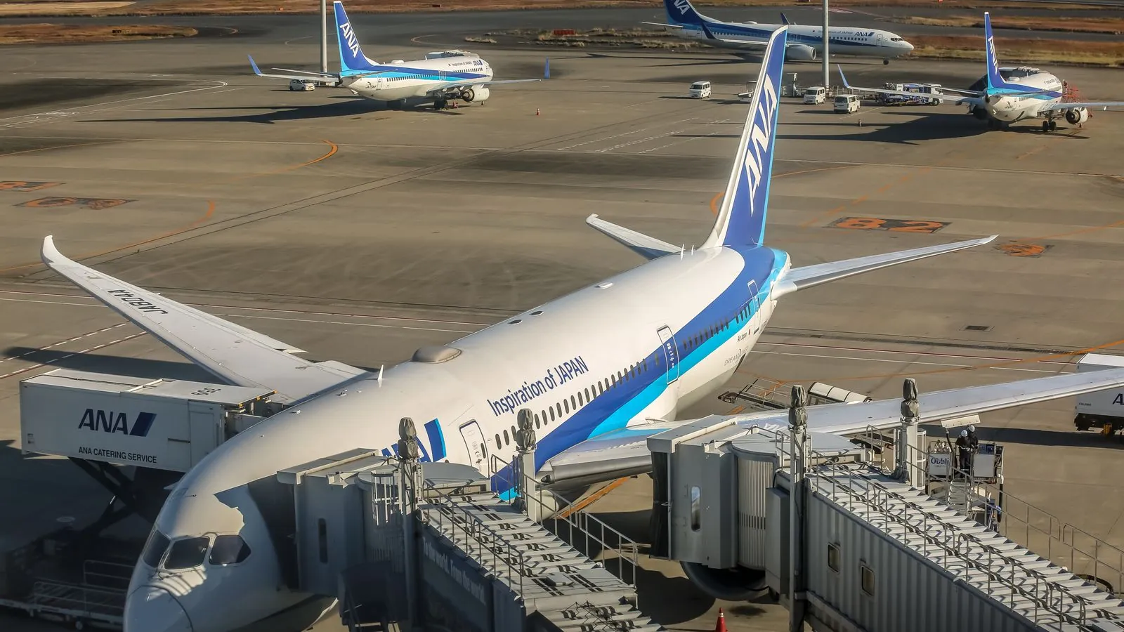 Aircraft parked at airport terminal with jet bridge, reflecting busy international travel.