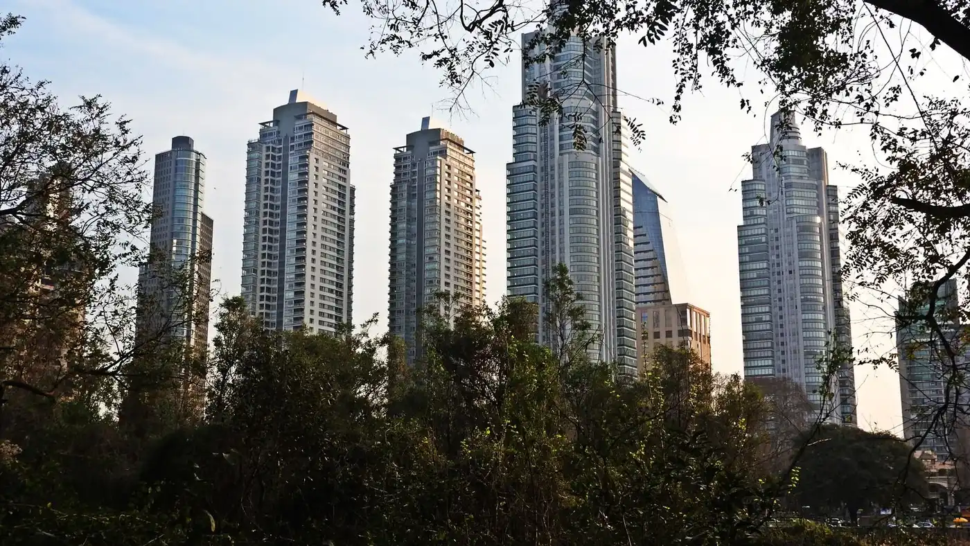 Skyline of Buenos Aires with tall skyscrapers surrounded by lush greenery.